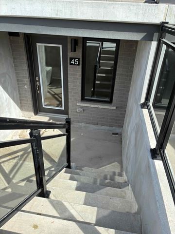 Fergus apartment for rent - A staircase with a black railing and a glass door with the number 45 on it.
