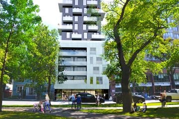 Halifax apartment for rent - A tall white building with balconies is surrounded by trees.