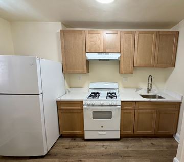 Washington apartment for rent - A white refrigerator sits next to a white stove in a kitchen.