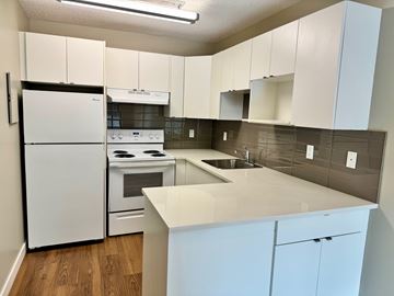 Calgary apartment for rent - A kitchen with white cabinets and a white fridge.