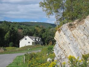 Pittsfield apartment for rent - A white house is situated in a green field.