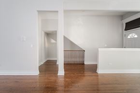 Chicago apartment for rent - a living room with white walls and a wooden floor and a staircase