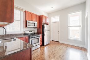 Chicago apartment for rent - an empty kitchen with wooden cabinets and stainless steel appliances