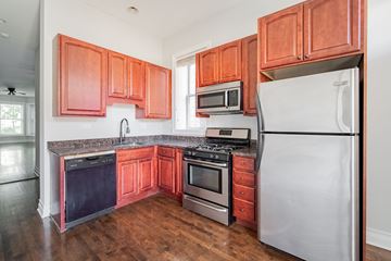 Chicago apartment for rent - a kitchen with wooden cabinets and stainless steel appliances
