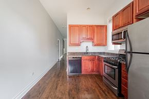 Chicago apartment for rent - an empty kitchen with wooden cabinets and stainless steel appliances