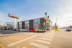 Chicago apartment for rent - a large building with cars parked in front of it at an intersection