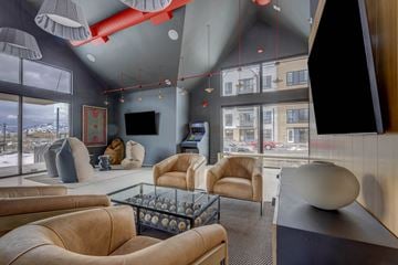 South Jordan apartment for rent - A modern living room with a glass coffee table and leather chairs.