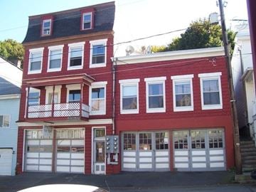 Ashland apartment for rent - A red building with white garage doors.