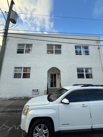 Miami apartment for rent - A white car is parked in front of a white building with a sign that says "No Parking".
