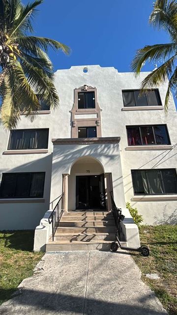 Miami apartment for rent - A white building with a staircase leading to the entrance.