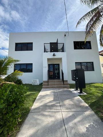 Miami apartment for rent - A white two-story building with a black mailbox and a "For Rent" sign on the front door.