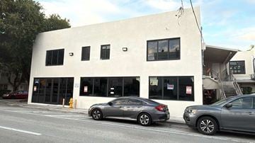 Miami apartment for rent - A white building with a grey car parked in front.