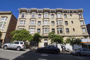 San Francisco apartment for rent - A silver car is parked on the street in front of a building.