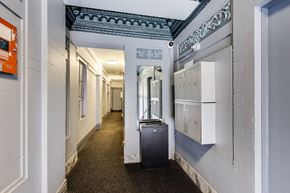 San Francisco apartment for rent - A long hallway with a trash can in the middle.