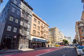 San Francisco apartment for rent - A city street with a red bike lane and parked cars.