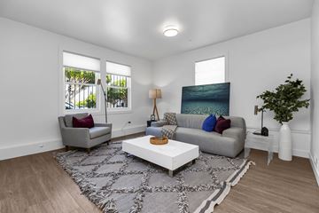 San Francisco apartment for rent - A living room with a grey couch, a white coffee table, and a painting on the wall.