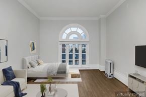 San Francisco apartment for rent - A bedroom with a large bed and a window overlooking the city.