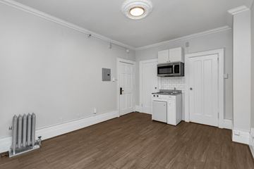 San Francisco apartment for rent - A white kitchen with wood flooring and a microwave above the stove.