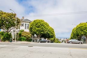 San Francisco apartment for rent - A street view with cars parked on the side of the road and a house in the background.