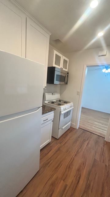 Inglewood apartment for rent - A kitchen with white appliances and wooden floors.