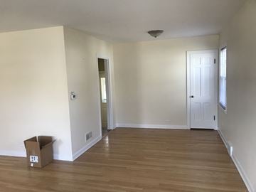 Skokie apartment for rent - A room with a wooden floor and a cardboard box on it.