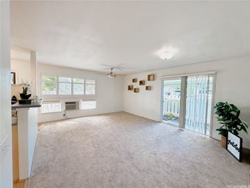 Mililani apartment for rent - A spacious living room with a ceiling fan and sliding glass doors.