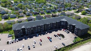 Moncton apartment for rent - A parking lot in front of a large building.