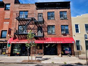 Queens apartment for rent - a brick building with a red awning and a fire escape