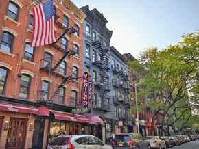 New York apartment for rent - a city street with cars and a flag on a building