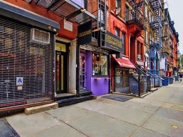 New York apartment for rent - a city street with colorful buildings and a sidewalk