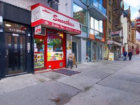New York apartment for rent - a supermarket with a red and white sign on a sidewalk