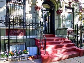 New York apartment for rent - a house with red steps and a black fence and a door