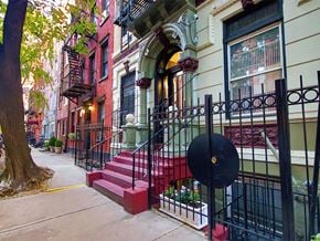 New York apartment for rent - a city street with red brick steps and a wrought iron fence