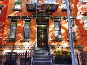 New York apartment for rent - A red brick building with a black door and windows.