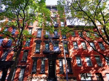 New York apartment for rent - A red brick building with black fire escapes.