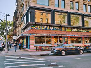 New York apartment for rent - a car parked in front of a music store on a city street