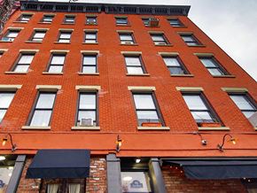 New York apartment for rent - a tall red brick building with many windows