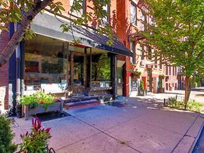 New York apartment for rent - a sidewalk in front of a store on a city street