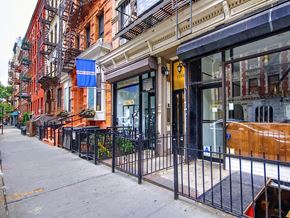 New York apartment for rent - a sidewalk in front of a store on a city street