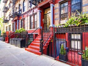 New York apartment for rent - a red house with red steps and a black fence
