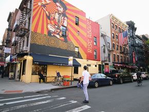 New York apartment for rent - a man crossing a street in front of a building