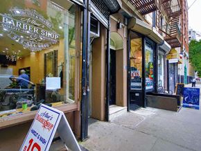 New York apartment for rent - a sign outside of a barber shop on the sidewalk