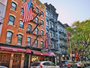 New York apartment for rent - a city street with cars and a flag on a building