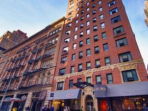 New York apartment for rent - a tall red brick building with a street in front of it