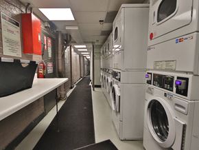 New York apartment for rent - a laundry room with a row of washing machines and dryers