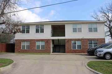 Belton apartment for rent - A two-story brick building with a white front and a garage door.