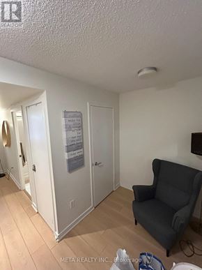 Toronto (Waterfront Communities) condo for rent - A room with a grey chair and a sign on the wall.