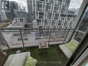 Toronto (Waterfront Communities) condo for rent - A balcony with a table and chairs overlooks a cityscape.