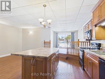 Kincardine other for rent - A kitchen with wooden cabinets and a black refrigerator.