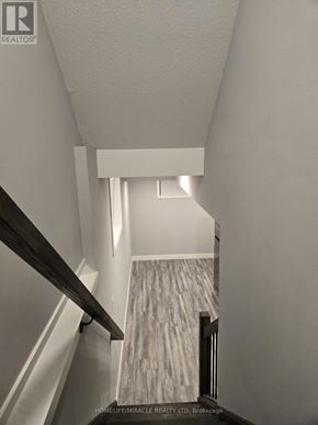 London South (South V) townhouse for rent - A hallway with a wooden staircase leading to a landing with a marble floor.